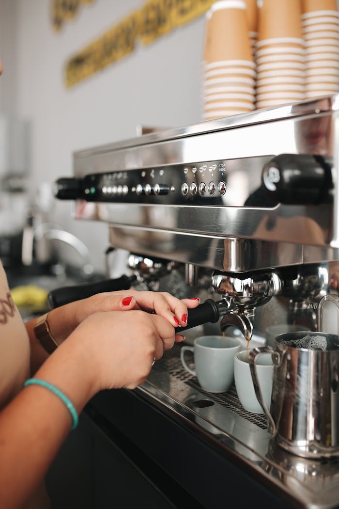 A barista using a coffee machine to prepare drinks at a café.